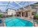 A crystal clear screened-in pool and patio area with outdoor seating for entertaining at 1410 Halapa Way, Trinity, FL 34655