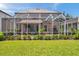 Landscaped backyard with screened in pool, patio, and lush green lawn at 1410 Halapa Way, Trinity, FL 34655