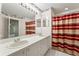 Bathroom featuring double sinks, a large mirror, and a shower with a striped curtain for added privacy at 1415 Pinewood Hills Ct, Spring Hill, FL 34606