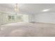 Large living room featuring vaulted ceilings, a chandelier, and large windows for natural light at 1415 Pinewood Hills Ct, Spring Hill, FL 34606