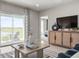 Well-decorated living room featuring stylish furniture, a large TV, and a view of the outdoors at 175 Voltaire Dr, Spring Hill, FL 34609