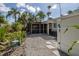 View of the backyard, showcasing a screened in porch and stone landscaping at 1830 Santa Barbara Dr, Dunedin, FL 34698