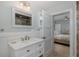 Clean bathroom with a marble countertop, white wainscoting and neutral tones at 1830 Santa Barbara Dr, Dunedin, FL 34698