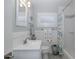 Bright bathroom with a vanity, linen closet, and a decorative shower curtain at 1830 Santa Barbara Dr, Dunedin, FL 34698