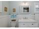 Well-lit bathroom with a white vanity and framed art at 1830 Santa Barbara Dr, Dunedin, FL 34698