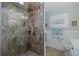 Tiled glass enclosed shower with an adjacent well lit bathroom and vanity at 1830 Santa Barbara Dr, Dunedin, FL 34698