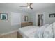 Relaxing bedroom featuring a dresser, a large window, and an open bathroom entrance at 1830 Santa Barbara Dr, Dunedin, FL 34698