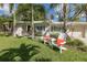 Cozy outdoor seating on a lush lawn, with a charming single-story home and beautiful landscaping in the background at 1830 Santa Barbara Dr, Dunedin, FL 34698