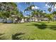 Lush front yard with palm trees, a charming single-story home, and inviting outdoor seating create a serene setting at 1830 Santa Barbara Dr, Dunedin, FL 34698