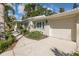 Well-maintained home with a lush landscaped front yard, a paved walkway, and an attached garage at 1830 Santa Barbara Dr, Dunedin, FL 34698