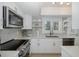 Well-lit kitchen with stainless steel appliances, tile backsplash, and modern fixtures at 1830 Santa Barbara Dr, Dunedin, FL 34698