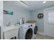 Laundry room includes newer front-load washer, dryer, utility sink and ample lighting at 1830 Santa Barbara Dr, Dunedin, FL 34698
