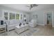 Comfortable living room with a ceiling fan, plush sofa, and bright natural light at 1830 Santa Barbara Dr, Dunedin, FL 34698