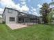 Expansive backyard featuring a screened-in patio, lush lawn, and well-maintained landscaping, perfect for outdoor living and entertaining at 19326 Long Lake Ranch Blvd, Lutz, FL 33558