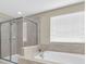 Clean bathroom featuring a glass shower, soaking tub, and tiled walls at 19326 Long Lake Ranch Blvd, Lutz, FL 33558