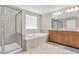 Bright bathroom featuring a glass shower, soaking tub, and a double vanity with granite countertops at 19326 Long Lake Ranch Blvd, Lutz, FL 33558