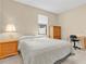 Neutral bedroom featuring a bed, nightstand, study area, and a window providing natural light at 19326 Long Lake Ranch Blvd, Lutz, FL 33558