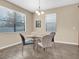 Cozy dining room featuring a round glass table, four chairs, and natural light from two windows at 19326 Long Lake Ranch Blvd, Lutz, FL 33558