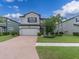 Lovely two-story home with a brick driveway, complemented by vibrant greenery and mature trees at 19326 Long Lake Ranch Blvd, Lutz, FL 33558