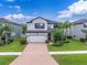 Beautifully landscaped two-story home with a two-car garage and a brick driveway at 19326 Long Lake Ranch Blvd, Lutz, FL 33558