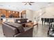 Inviting living room with leather sofas, piano, and seamless flow to a modern kitchen at 19326 Long Lake Ranch Blvd, Lutz, FL 33558