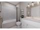 Well-lit bathroom with white vanity, framed mirror and shower-tub combo with gray and white shower curtain at 20021 Golden Glow Loop, Venice, FL 34292