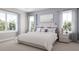 Bright bedroom featuring a bed dressed in white linens flanked by matching nightstands and picturesque windows at 20021 Golden Glow Loop, Venice, FL 34292