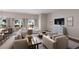 Bright living room featuring stylish furniture, a large TV, and access to the outdoor space at 20021 Golden Glow Loop, Venice, FL 34292