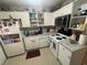 Well-lit kitchen featuring essential appliances, open shelving, and white cabinets at 203 Pine Violet Ct # 202, Tampa, FL 33612