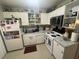 Bright kitchen with white appliances, open shelving, and granite countertops at 203 Pine Violet Ct # 202, Tampa, FL 33612