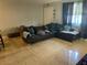 Open-concept living room with tile flooring, natural light, and a comfortable sofa at 203 Pine Violet Ct # 202, Tampa, FL 33612