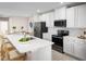 Modern kitchen featuring white cabinets, stainless steel appliances, and a large center island with seating at 272 Voltaire Dr, Spring Hill, FL 34609