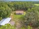 Aerial view of a charming home surrounded by lush greenery and trees in a rural area at 27295 Tarbel Rd, Brooksville, FL 34602