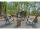 Backyard firepit area has four Adirondack chairs and log stools at 27295 Tarbel Rd, Brooksville, FL 34602