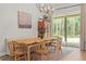 Bright dining room features rustic wood table, modern chandelier, and sliding glass doors at 27295 Tarbel Rd, Brooksville, FL 34602