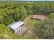 Exterior view of home and large outbuilding surrounded by tall trees, offering a country feel at 27295 Tarbel Rd, Brooksville, FL 34602