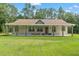 A single story home has a large front porch and front lawn at 27295 Tarbel Rd, Brooksville, FL 34602