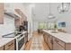 Modern kitchen with stainless steel appliances, island with quartz countertop, and hardwood flooring at 27295 Tarbel Rd, Brooksville, FL 34602