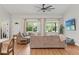 Cozy living room features a comfortable sectional sofa, large windows and a ceiling fan at 27295 Tarbel Rd, Brooksville, FL 34602
