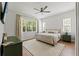 Light and airy main bedroom with large window, neutral color palette, and ceiling fan at 27295 Tarbel Rd, Brooksville, FL 34602