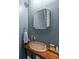 Chic powder room featuring dark blue walls, vessel sink, and a stylish mirror at 27295 Tarbel Rd, Brooksville, FL 34602