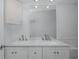 Bright bathroom featuring a double sink vanity with white cabinets and a large mirror at 3150 Trident Ter, New Port Richey, FL 34652