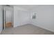 Bedroom featuring neutral carpet, window, closet and an open doorway at 3150 Trident Ter, New Port Richey, FL 34652