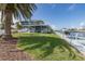 Back exterior featuring a beautiful house with yard, boat dock, lift, and canal access, embodying waterfront living at 3150 Trident Ter, New Port Richey, FL 34652