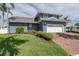Charming two-story waterfront home features a brick driveway, lush lawn, and manicured landscaping at 3150 Trident Ter, New Port Richey, FL 34652