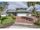 Charming two-story waterfront home features a brick driveway, lush lawn, and mature palm trees at 3150 Trident Ter, New Port Richey, FL 34652