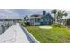 A cozy blue home with a screened porch, lush green lawn, and waterfront access at 3150 Trident Ter, New Port Richey, FL 34652