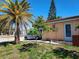 Side view of a single-story home showcasing the driveway and tropical landscaping at 3206 Pinon Dr, Holiday, FL 34691