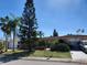 Charming single-story home with lush landscaping and a well-manicured front yard under a bright blue sky at 3206 Pinon Dr, Holiday, FL 34691