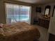 Comfortable main bedroom with view and sliding glass doors to the pool area at 3206 Pinon Dr, Holiday, FL 34691